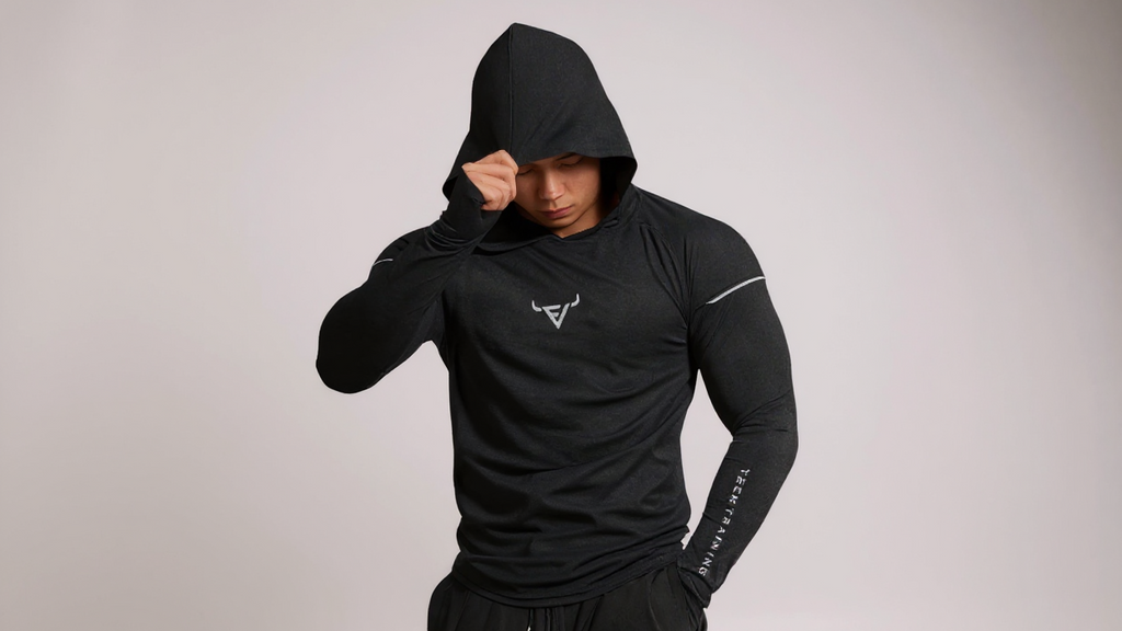 Haut d’entraînement homme à capuche, manches longues slim-fit avec passages pour pouces, tissu respirant et léger, idéal pour course et musculation.